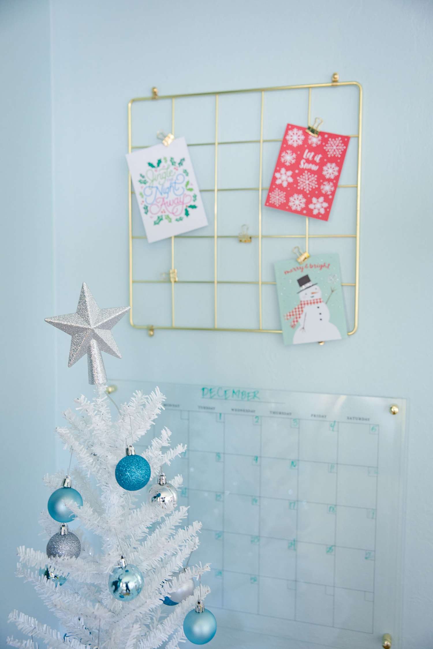 Tarjetas de Navidad expuestas en un tablero dorado en un dormitorio infantil