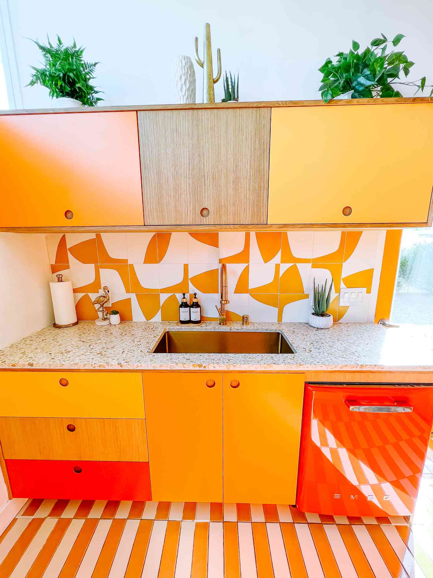 Salpicadero de cocina naranja estampado con elementos amarillos, blancos y rojos