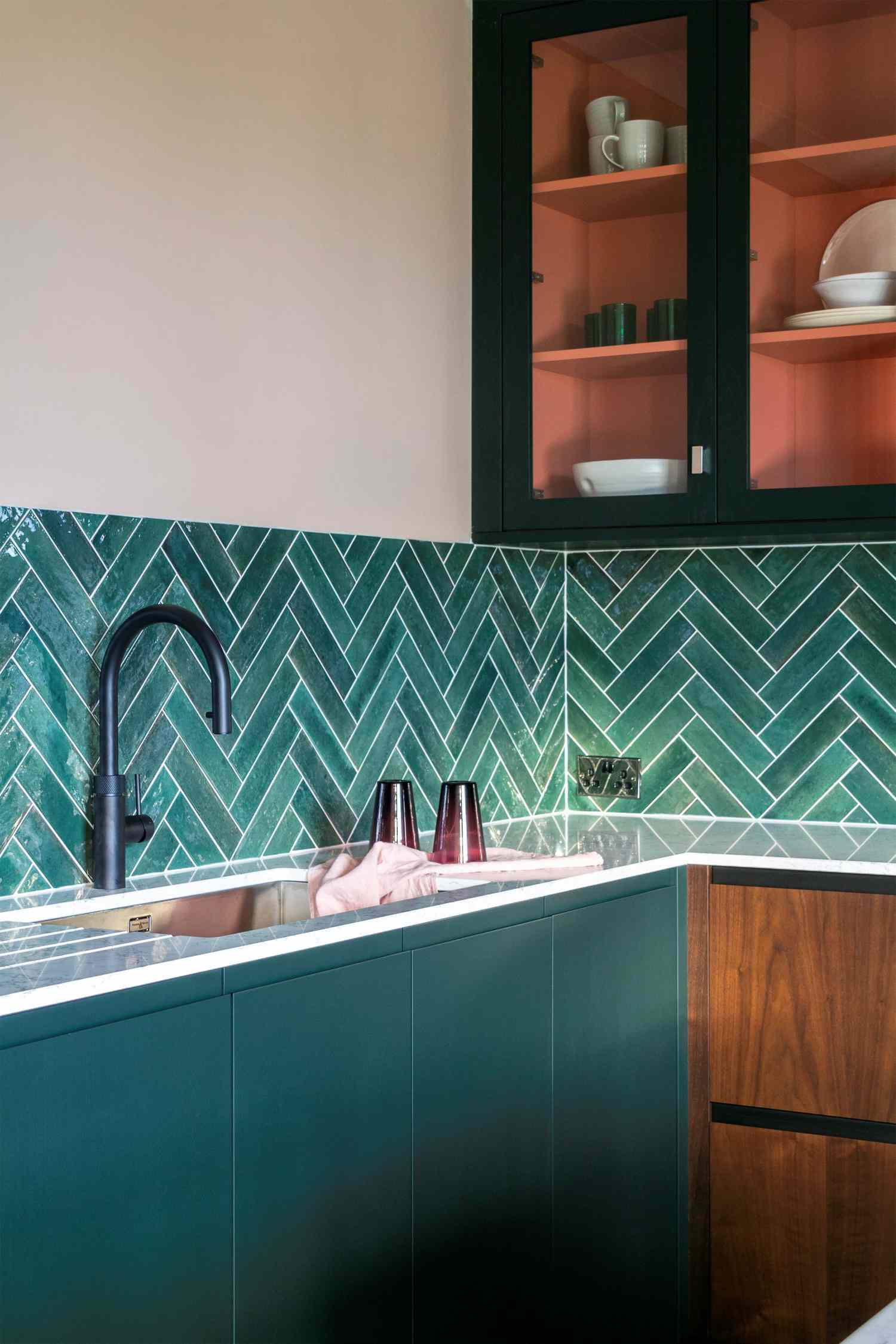 Cocina verde con armarios de puertas de cristal e interior albaricoque