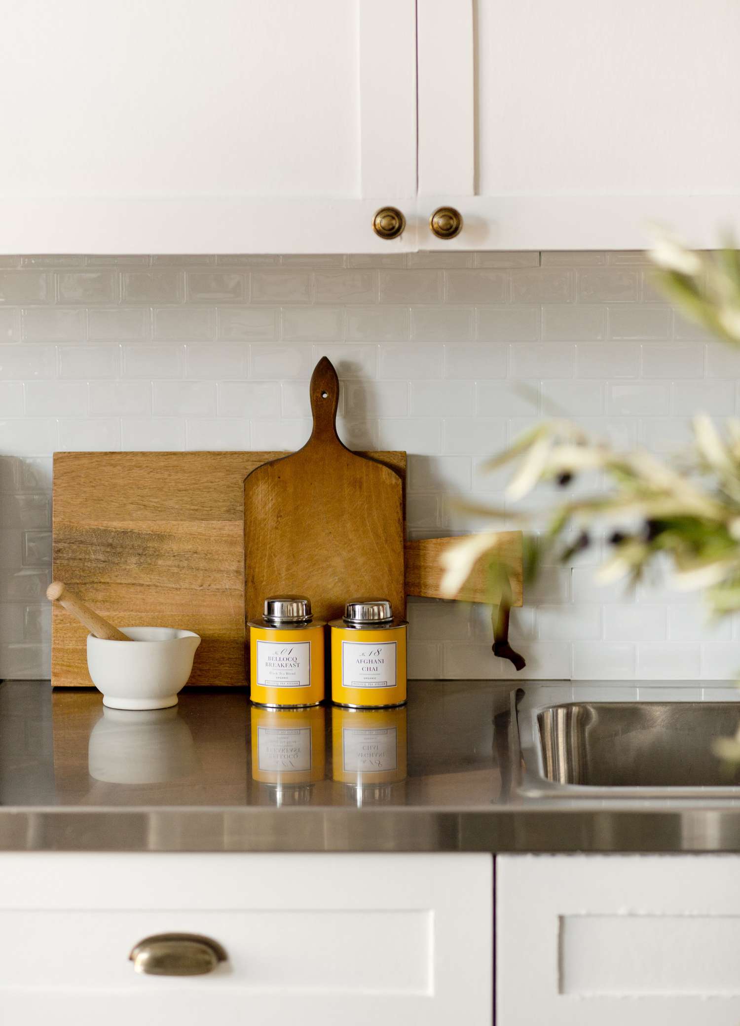 Cocina blanca con latas de té y tablas de cortar naranjas