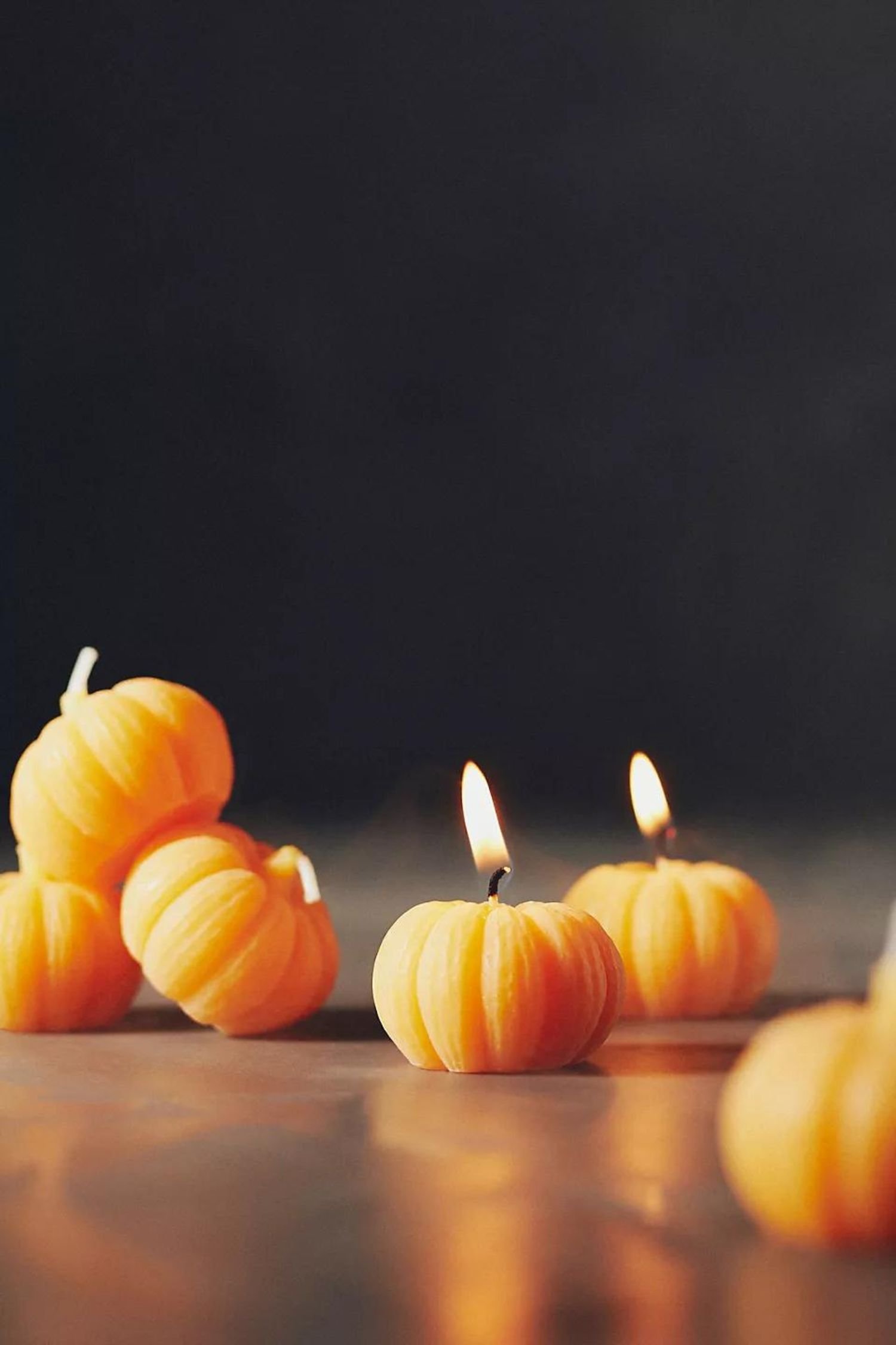 Un juego de pequeñas velas naranjas con forma de calabaza