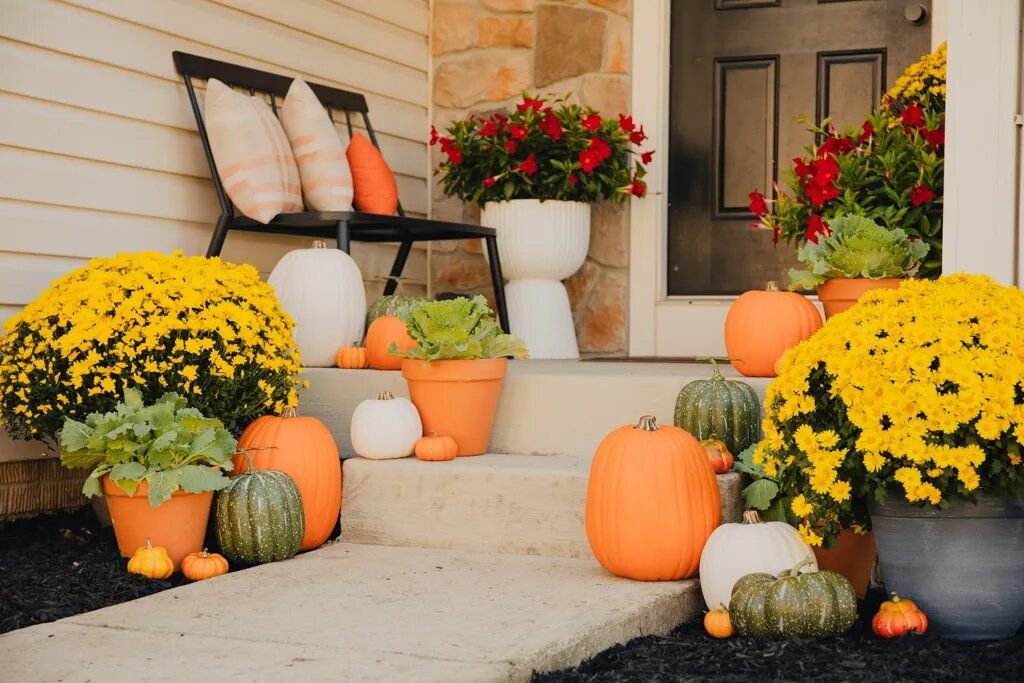 Calabazas naranja neón y crisantemos amarillo brillante