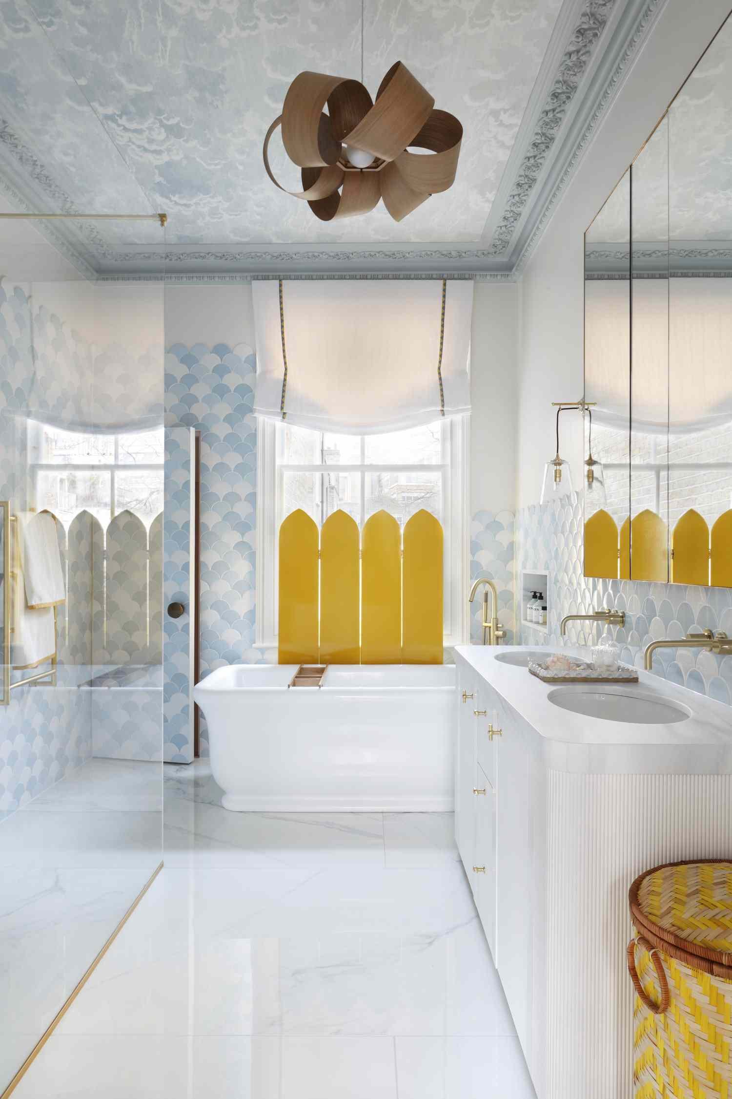 Cuarto de baño con azulejos y papel pintado en el techo de color azul claro y cortina de ventana de color amarillo brillante